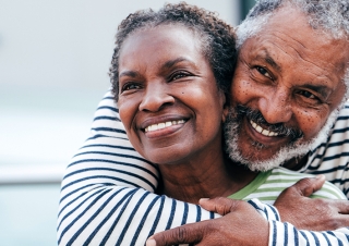 Man and woman hugging facing forwards